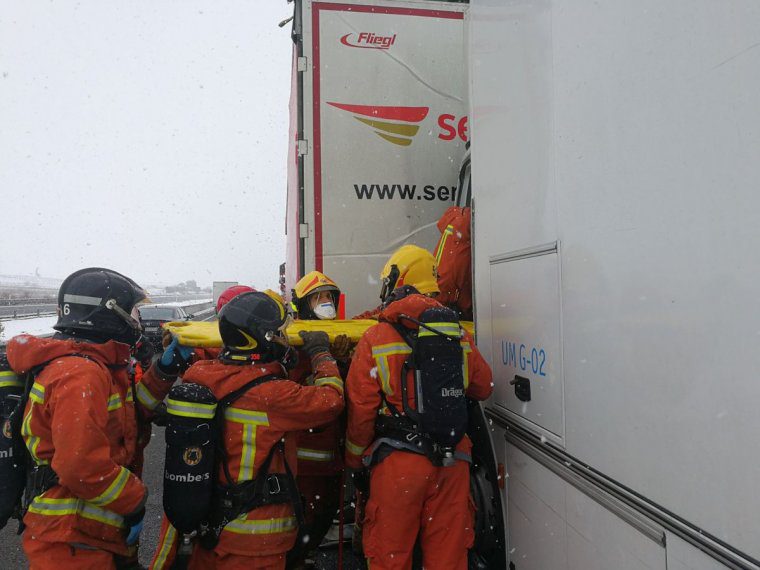 Els bombers excarceren al conductor d'un dels dos camions afectats