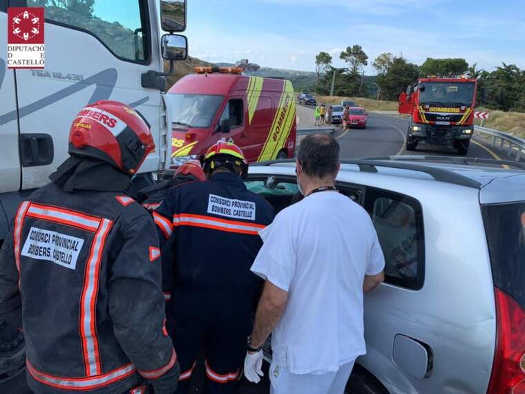 Bombers i sanitaris ajudant al conductor del cotxe