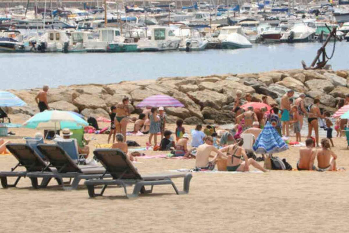Diverses persones a la platja de Sant Feliu de GuÃ­xols