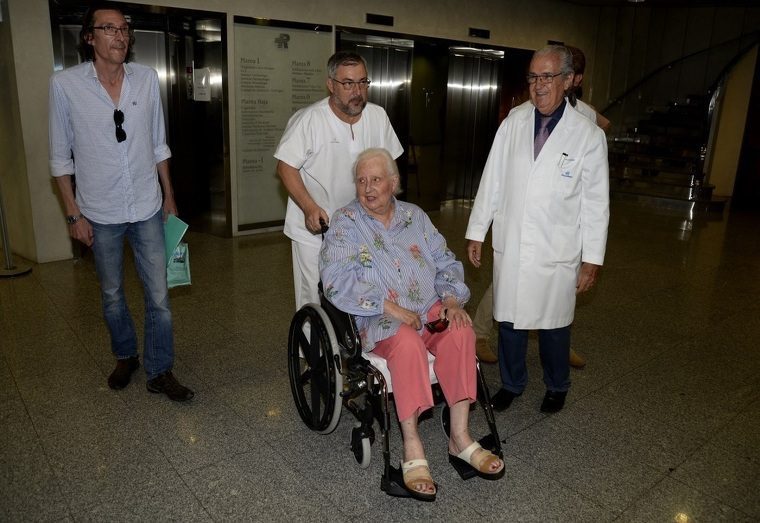 La infanta Pilar acompanyada per un zelador i un metge a la sortida de la clÃ­nica mallorquina