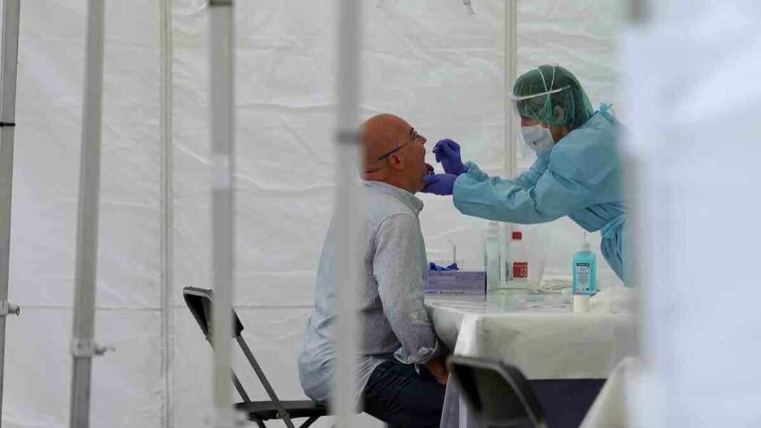 Una sanitària realitzant una prova PCR a un home
