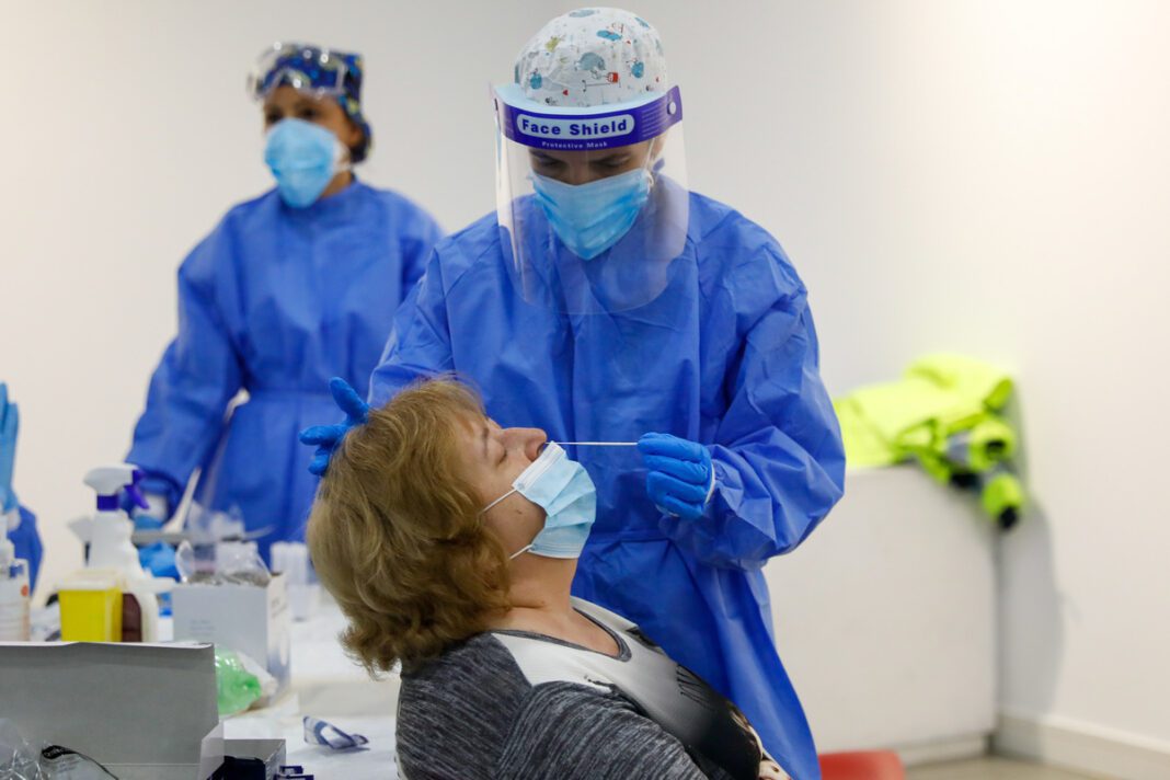 Sanitarios realizando una prueba pcr para el coronavirus a una mujer