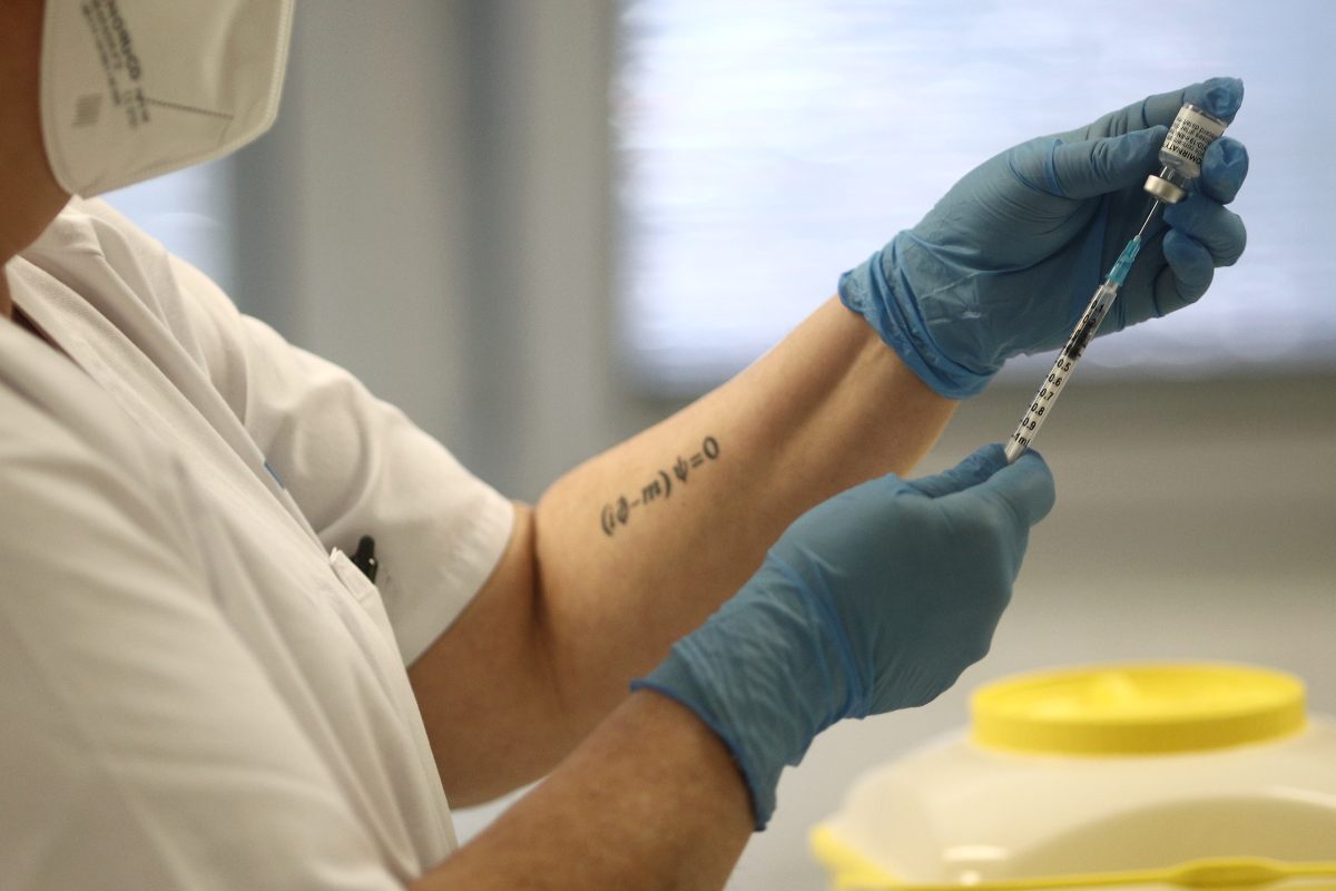 Una sanità ria sosté una dosi de la vacuna de Pfizer abans d'administrar-la a un pacient
