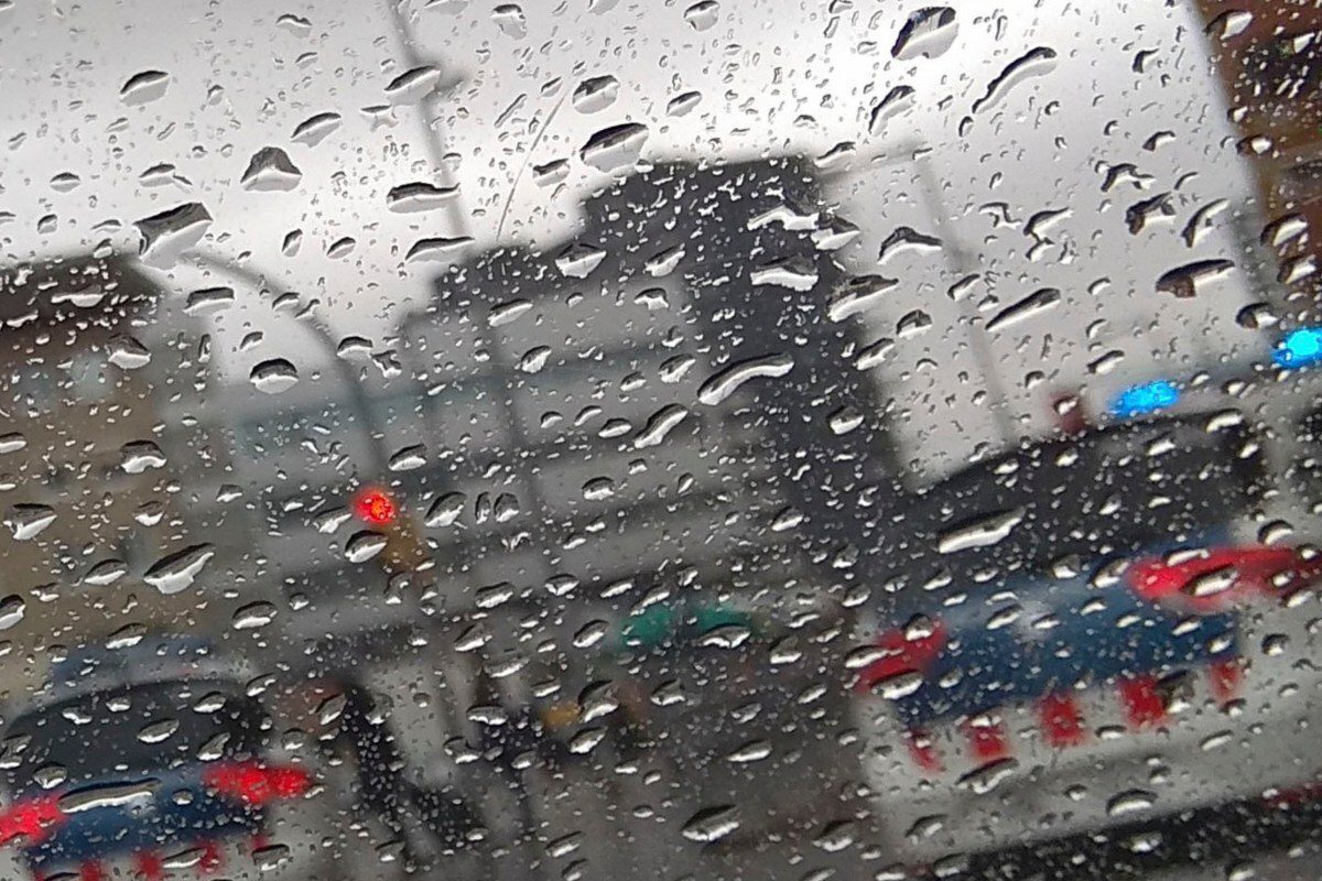 Dos cotxes dels Mossos d'Esquadra vistos per una finestra amb gotes d'aigua de pluja